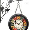 Vintage black wrought iron hanging wall clock with floral and bird design, featuring colorful distressed numerals.