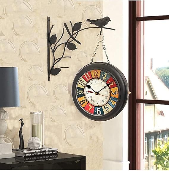 Vintage black wrought iron hanging wall clock with floral and bird design, featuring colorful distressed numerals.